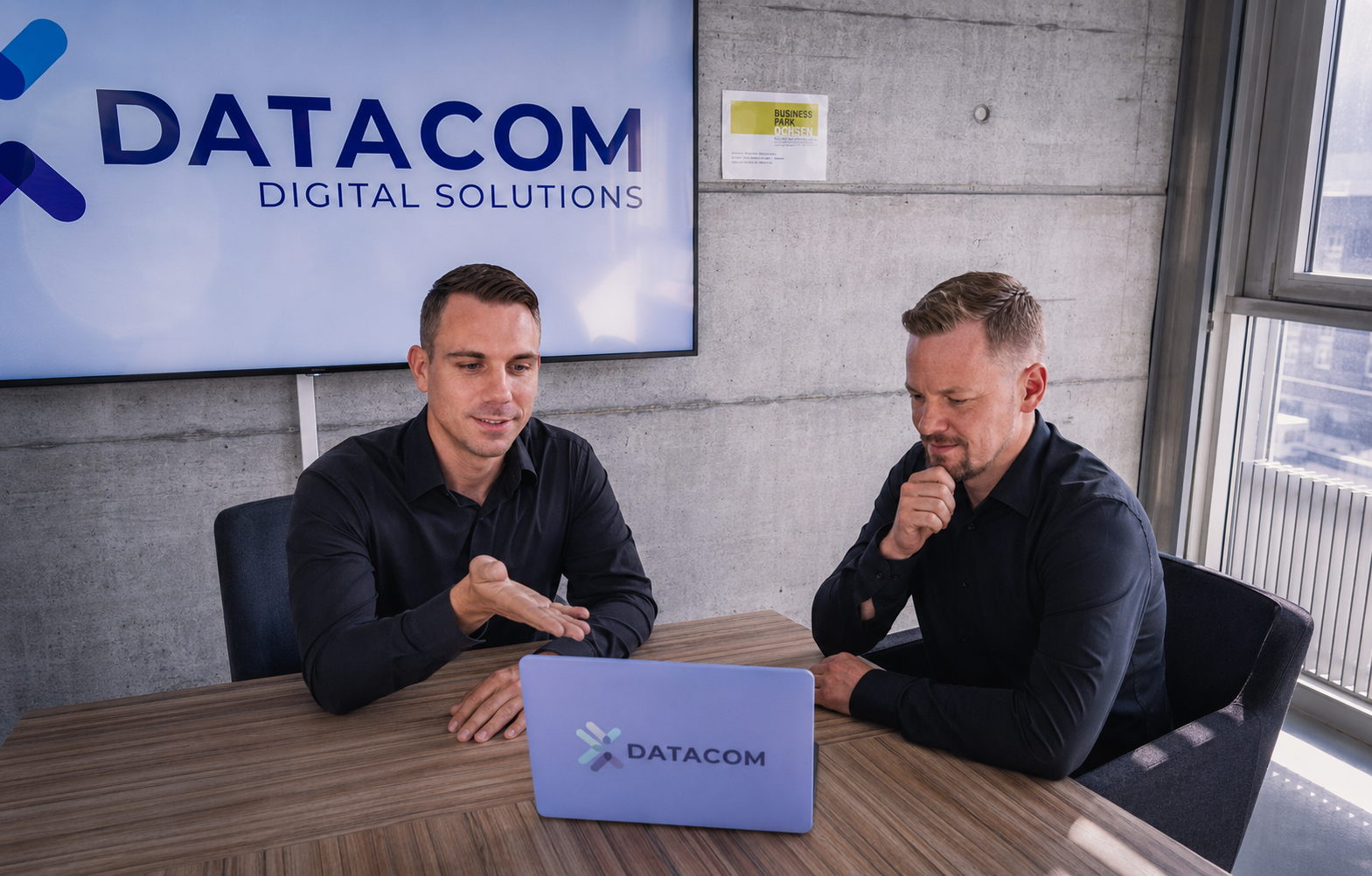 Zwei Mitglieder des Teams IT Support & Digital Marketing sitzen for einem Laptop